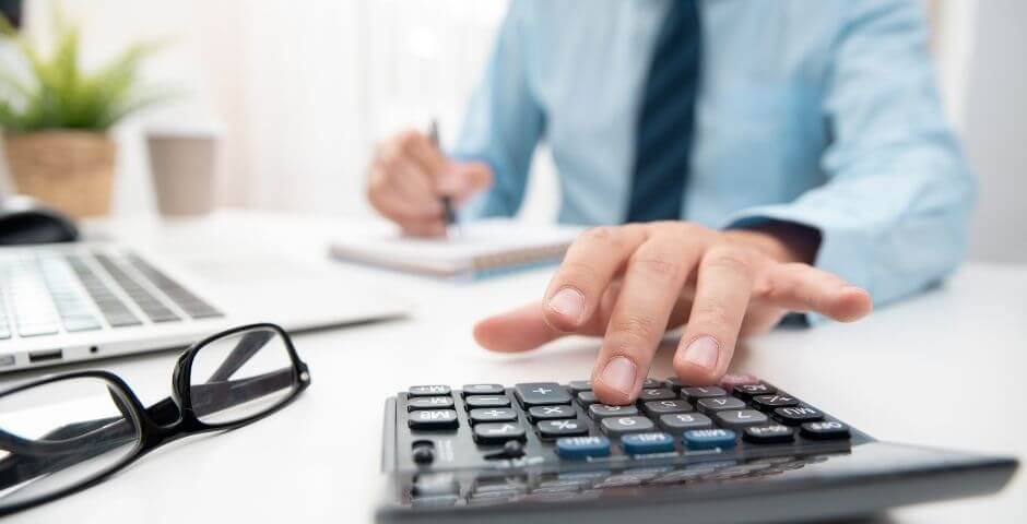 declaracao-do-imposto-de-renda homem faz cálculo na calculadora para descobrir quanto terá de pagar de imposto de renda